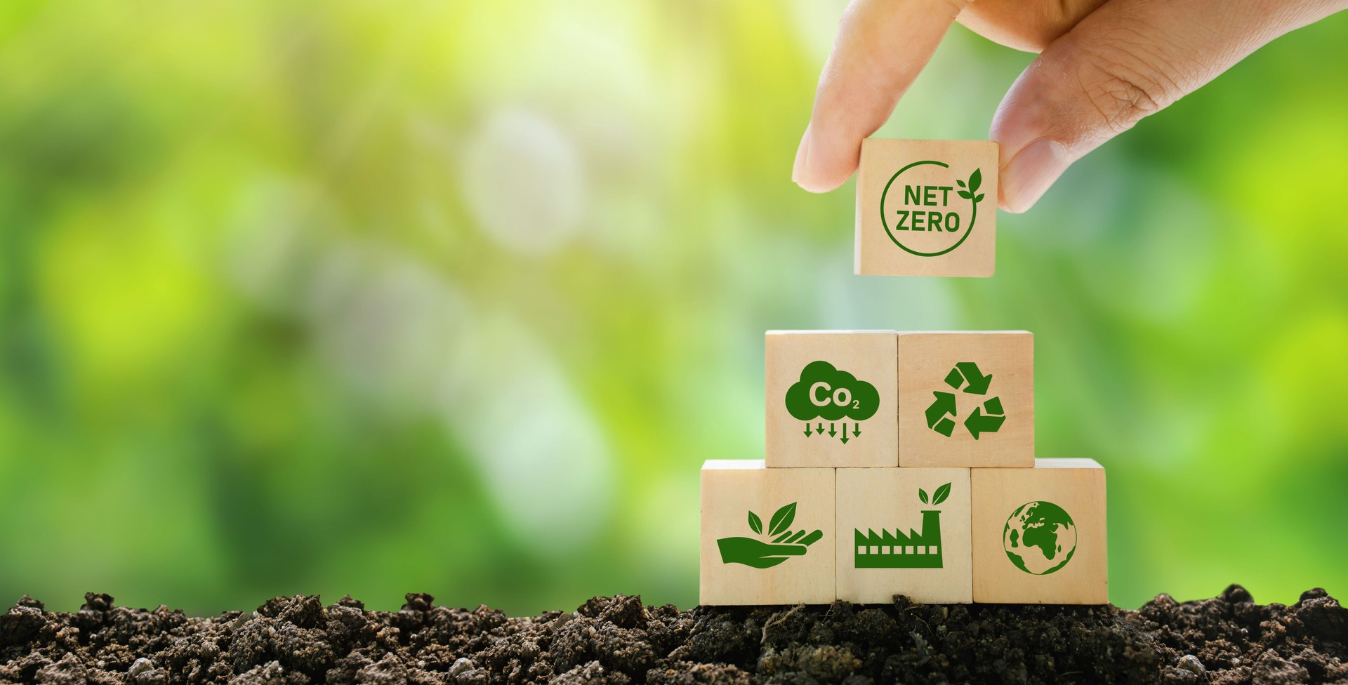 Net Zero and Carbon Neutral Concepts Net Zero Emissions Goals A climate-neutral long-term strategy Ready to put wooden blocks by hand with green net center icon and green icon on gray background.